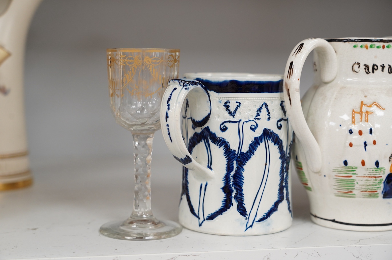 An 18th century pearlware mug, an 18th century Italian maiolica wet drug jar, a faceted wine glass, a commemorative jug and a pair of Bristol blue glass decanters and stoppers, tallest 19cm. Condition - varies